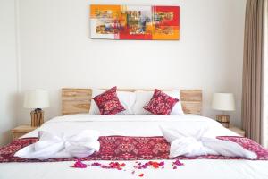 Un dormitorio con una cama con almohadas rojas y blancas. en Seno Guesthouse & Cafe, en Uluwatu