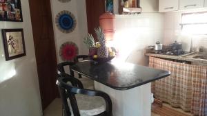 a small kitchen with a table with a pineapple on it at Casa temporada na praia Joia do Atlântico - Ilhéus - Ba in Ilhéus