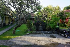 a motorcycle parked in a yard next to a house at Pondok Bali Sea View Bungalow in Lovina