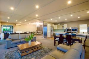 - un salon avec un canapé et une table dans l'établissement Lake Hayes Luxury Residence, à Queenstown