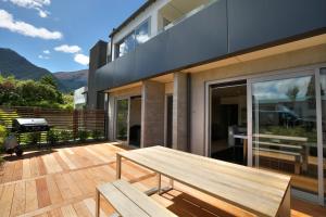 a wooden bench on the deck of a house at Diamond Luxury Central Queenstown in Queenstown