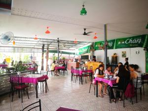 a group of people sitting at tables in a restaurant at Smiley frog in Kanchanaburi City