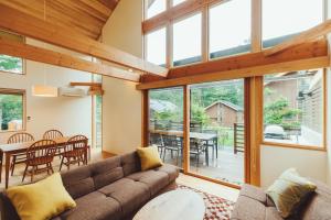 a living room with a couch and a table and chairs at PICA Fujiyama in Fujikawaguchiko
