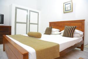 1 dormitorio con 1 cama grande con sábanas y almohadas blancas en Ranveli Beach Resort en Mount Lavinia