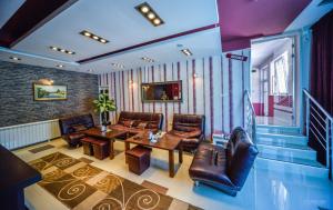 Garni Hotel 018 In في نيشْ: غرفة معيشة مع كراسي جلدية وطاولة