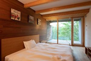a bedroom with a bed and a large window at Sekka House in Niseko