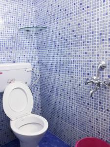 a bathroom with a toilet in a tiled wall at seaway's inn in Cochin