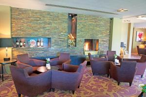 a waiting room with chairs and a fireplace at Fletcher Hotel Restaurant Sallandse Heuvelrug in Rijssen