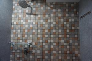 a shower in a bathroom with a tiled floor at BRB Guesthouse in Banyuwangi
