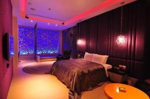 1 dormitorio con cama e iluminación púrpura en Qixing Jingpin Motel, en Ho-mei