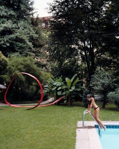 a woman in a bikini jumping into a swimming pool at Parkhotel Laurin in Bolzano