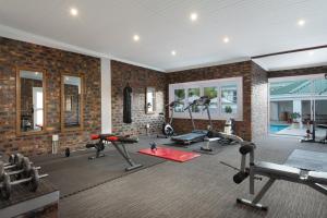 a gym with several tread machines and a brick wall at Citrusdal Country Lodge in Citrusdal