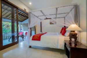 sypialnia z łóżkiem z baldachimem w obiekcie Manuaba Inn w mieście Ubud