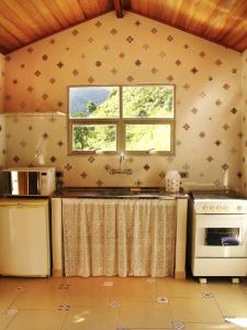 a kitchen with a stove and a window at Chalés de Valfena in São Francisco Xavier