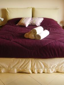 a purple bed with towels and pillows on it at Chalés de Valfena in São Francisco Xavier
