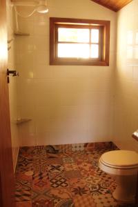 a bathroom with a toilet and a window at Chalés de Valfena in São Francisco Xavier +17 photos