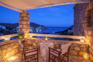a table and chairs on a balcony with a view of the ocean at Theologos Houses in Grikos