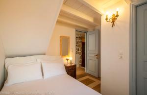 a white bed with white pillows in a bedroom at Theologos Houses in Grikos