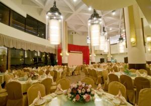 a banquet hall with tables and chairs and flowers at CHIENTAN Youth Hotel in Taipei