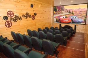 a movie room with chairs and a painting of a car at Sycamore Mansion in Pittman Center