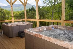 two hot tubs on a wooden deck with a view at Sycamore Mansion in Pittman Center