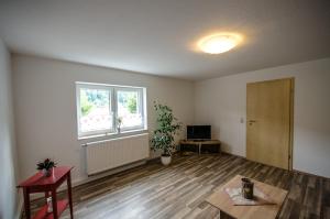 een lege woonkamer met een tafel en een raam bij Ferienwohnung an der Habe in Bad Schandau