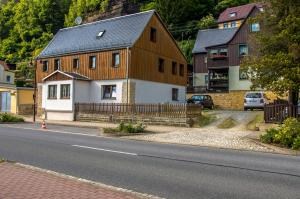 a large wooden house on the side of a street at Ferienwohnung an der Habe in Bad Schandau