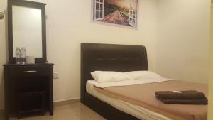 a bedroom with a bed with a black headboard and a mirror at Win Win in Genting Highlands