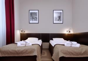 Dos camas en una habitación de hotel con toallas. en Hotel Picaro Kraśnik Dolny, en Bolesławiec