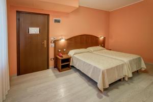 una camera con un grande letto e una porta in legno di Hotel Italia a Trieste