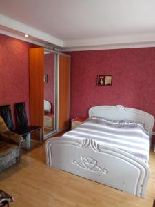 sypialnia z białym łóżkiem i różowymi ścianami w obiekcie Домик у моря w Odessie