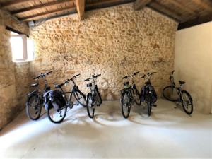 cuatro bicicletas están alineadas contra una pared en Domaine de Ludeye en Listrac-Médoc