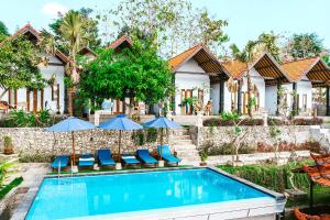 ein Haus mit einem Pool mit Stühlen und Sonnenschirmen in der Unterkunft Lime Penida Cottages in Nusa Penida