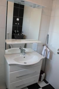 La salle de bains est pourvue d'un lavabo blanc et d'un miroir. dans l'établissement Apartmani Vrsi Mulo, à Vrsi