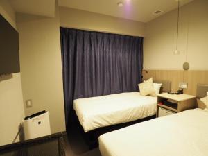 a hotel room with two beds and a window at Haneda Inn in Tokyo