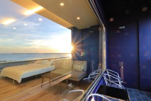 a room with a bed and a view of the ocean at Two Home Inn in Hualien City