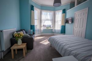Un dormitorio con una cama y un sofá y una ventana. en Clydesdale Apartments, en Torquay