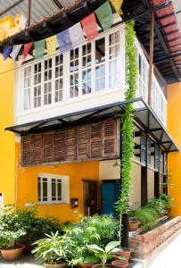 a yellow building with prayer flags in front of it at 5/4 - Calcutta's freshest BnB in Kolkata