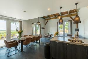 a large dining room with a long table and chairs at Welcome in - Vakantiehuis 't Zwartje met ruime tuin I Lepelstraat 18B in Vrouwenpolder