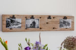 a wooden picture frame with pictures on a wall at Welcome in - Vakantiehuis 't Zwartje met ruime tuin I Lepelstraat 18B in Vrouwenpolder
