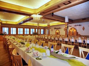 um grande salão de banquetes com mesas e cadeiras brancas em Weinhotel Goger em Sand