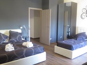 1 dormitorio con 2 camas y espejo en Symposium Bed&Breakfast, en Catania