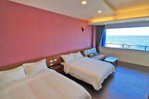 a hotel room with two beds and a large window at Two Home Inn in Hualien City