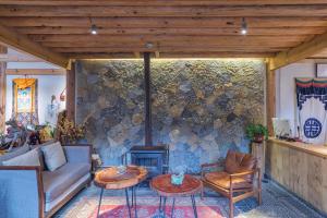 a living room with a couch and a stone wall at Arro Khampa by Zinc Journey Lijiang in Lijiang