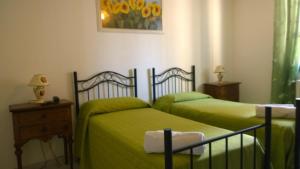 2 camas en un dormitorio con sábanas verdes en B&B Salento Vacanze, en Maglie