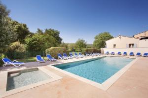a swimming pool with lounge chairs and a swimming pool at Résidence Odalys Les 4 soleils in Bonnieux