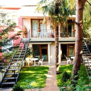 a house with stairs leading to a patio with palm trees at Kumsal Butik Otel in Istanbul