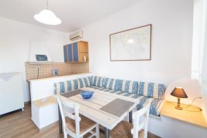 a kitchen and dining room with a table and a couch at Porto Bello Tinos in Agios Ioannis