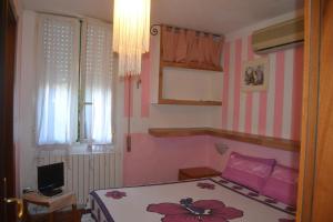ein Schlafzimmer mit einem Bett und einem TV. in der Unterkunft B&B Miramare in Platamona