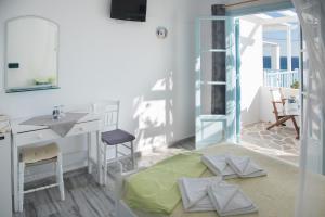 Zimmer mit einem Bett, einem Waschbecken und einem Spiegel in der Unterkunft Paroscarmel studio-apartment in Logaras